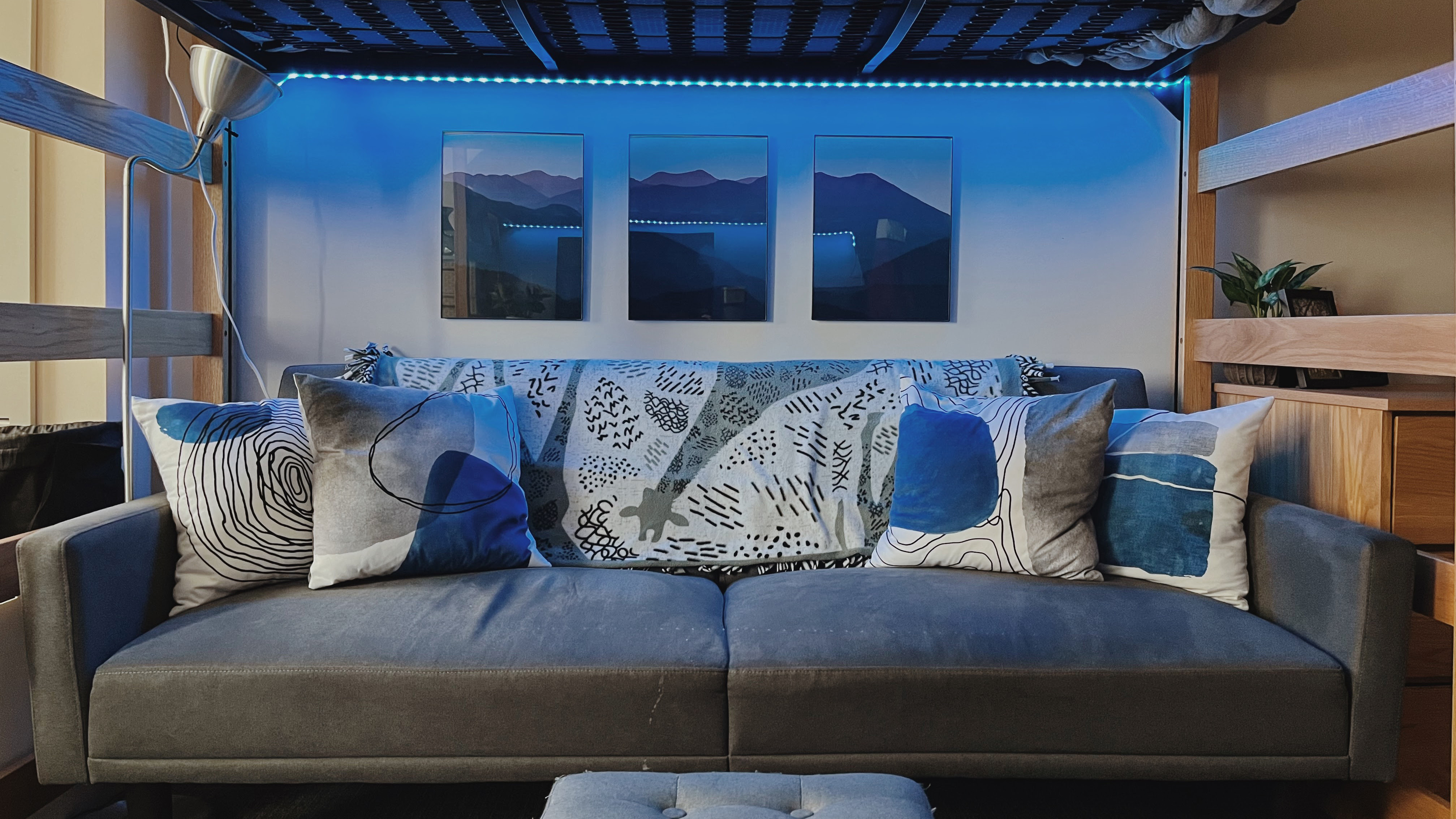 2024 Minimalist Room a grey couch under a lofted bed with white and blue pillows.