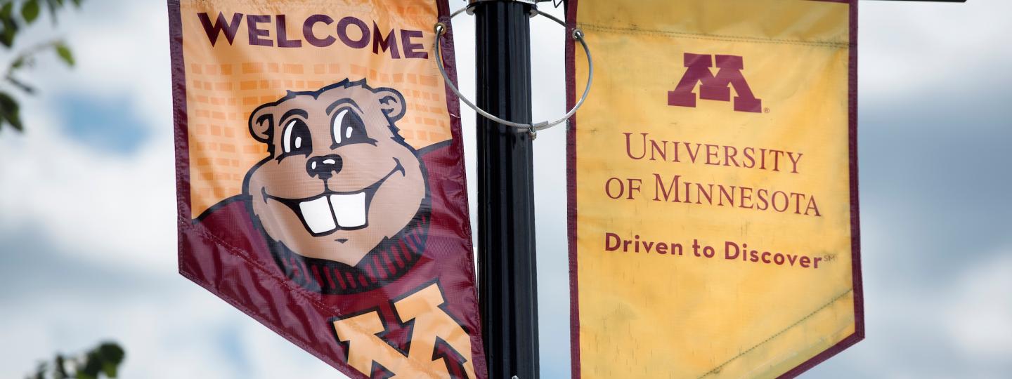 U of M flagpole signs depicting Goldy Gopher and the university logo.