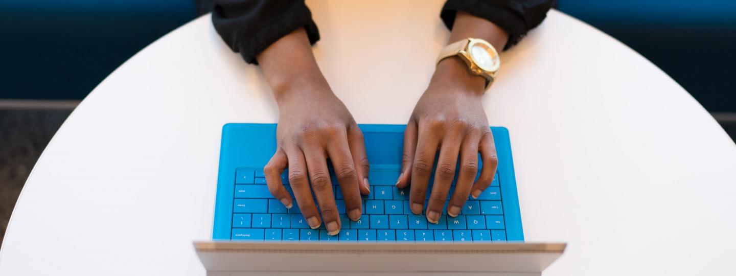 Student typing on a blue tablet keyboard