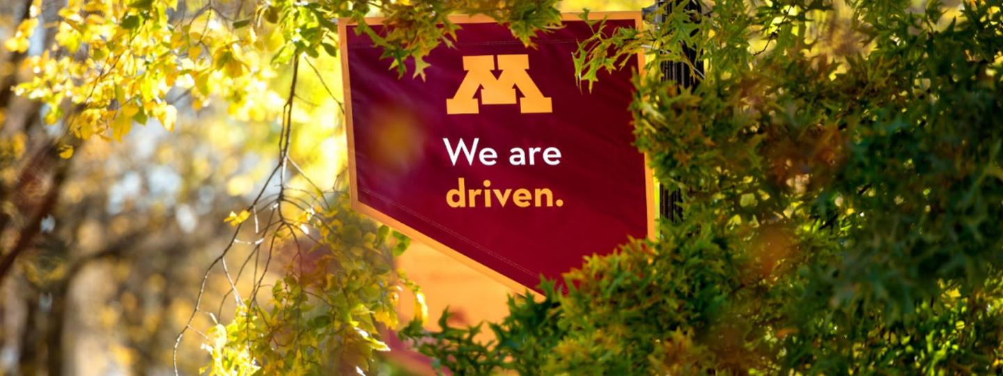 UMN Campus Mall Banner: "We Are Driven"