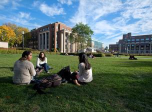 Small group of students sit together on East Bank mall lawn.