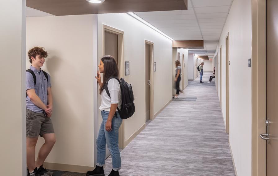 Students standing in a corridor outside resident rooms